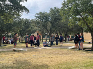 Students playing cornhole on the quad